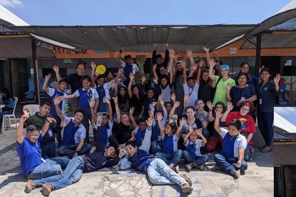 Groupe d'une trentaine de jeunes québécois et guatémaltèques avec des intervenant devant une école au Guatemala