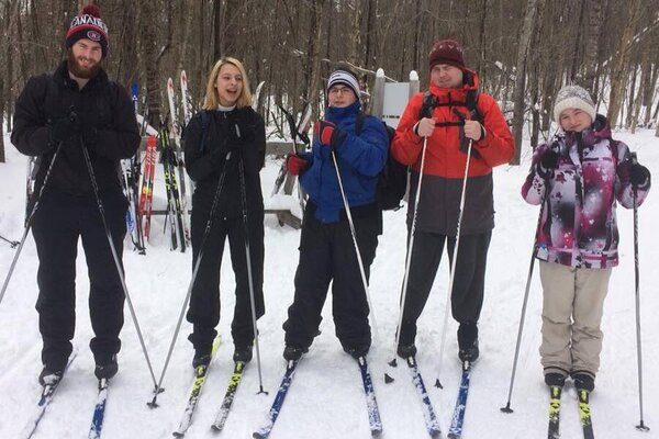 4 jeunes participants à une activité de ski de fond avec un intervenant